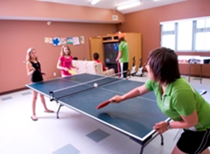 Kids play ping pong in a recreation centre