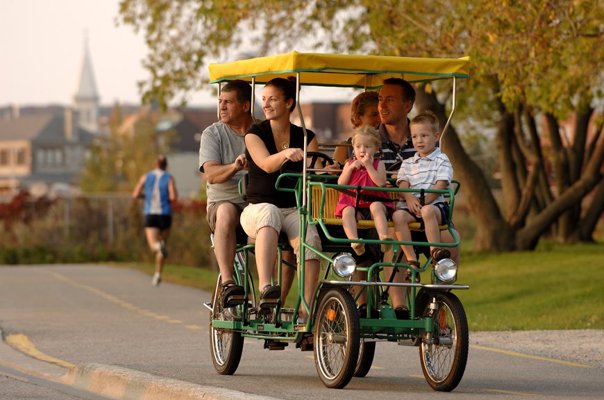 Family riding a 4 person bike