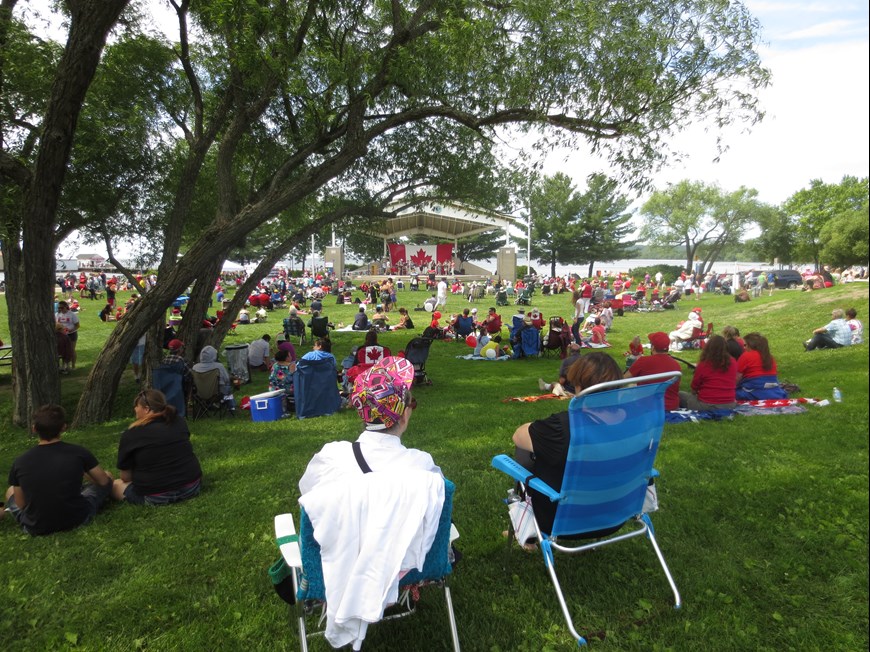 Residents sitting on the grass at a Canada Day  event